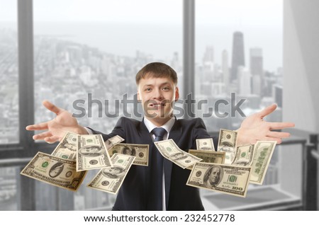 Happy young businessman throwing dollar