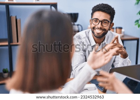 Man and woman business workers using laptop speaking at office
