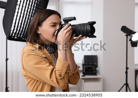 Professional photographer taking picture in modern photo studio