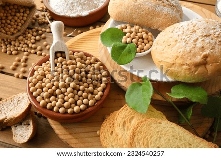 Bread made with soy flour on rustic wooden table with bread, flour and soy beans in the countryside. Elevated view. Royalty-Free Stock Photo #2324540257