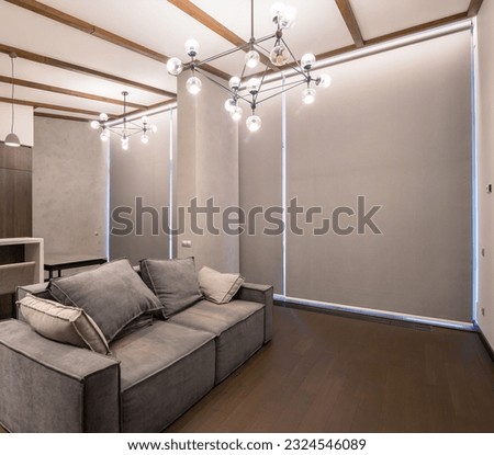 Roller blinds in the interior. Automatic blackout shades on the full height windows. Modern interior with glass wall. Pastel-colored interior. Electric curtains for smart home.  Royalty-Free Stock Photo #2324546089