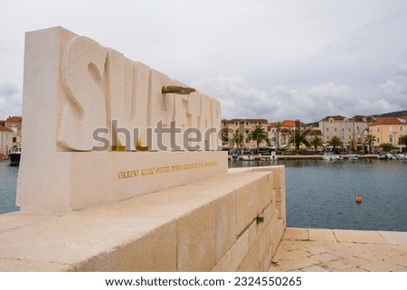 The harbour sign in Supetar port on Brac Island in Croatia. The text says "Turn the key of St. Peter and the location of paradise will be revealed to you"
