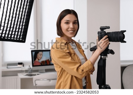 Professional photographer working with camera in modern photo studio