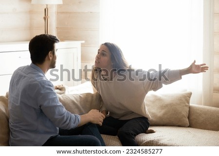 Misunderstanding. Angry worried young spouses quarreling arguing at home, annoyed nervous millennial wife shouting screaming on frustrated husband accusing in cheat threatening with breakup divorce Royalty-Free Stock Photo #2324585277