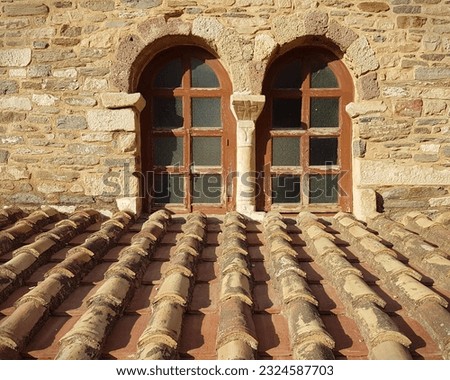 A window and roof details of a historical orthodox church drom a Greek island