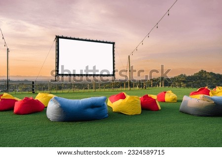 open air cinema with colorful bean bag. empty white screen, free space for text or montage Royalty-Free Stock Photo #2324589715