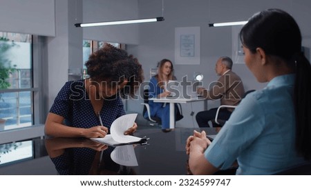 African-American young woman sign rental agreement in real estate office. Bank manager give loan contract to customer for signature