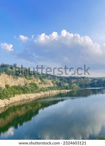 beautiful landscape of mountains and water, mountains are reflected in the water, blue sky from above, green trees