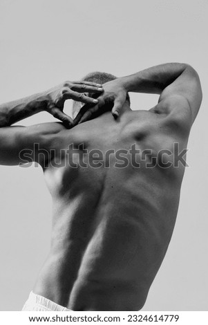 Male body aesthetics. Black and white image of strong, muscular, beautiful, relief male back. Healthy body shape. Concept of male natural beauty, body care, health, sport, fashion, ad Royalty-Free Stock Photo #2324614779