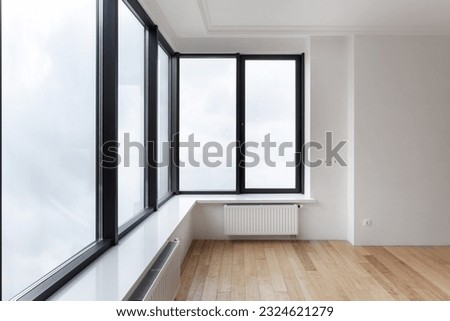 empty room with white walls, wooden laminate floor and new plastic windows. concept of new apartment after renovation Royalty-Free Stock Photo #2324621279