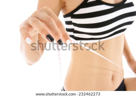 Woman's hand holding a tape measure on white background