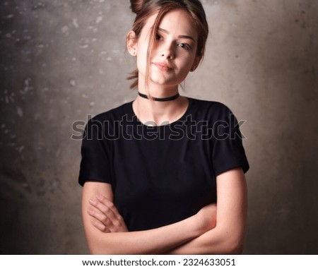 Mockup, template of a black t-shirt on a young beautiful girl on a gray background. Studio photo. Royalty-Free Stock Photo #2324633051