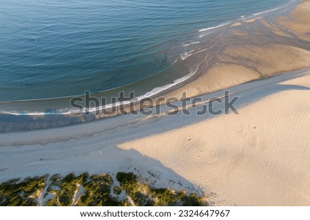 drone aerial view from above of a calm water beach at sunrise