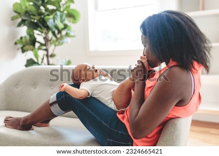 A portrait of beautiful young American mother with baby at home