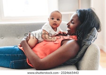 A portrait of beautiful young American mother with baby at home