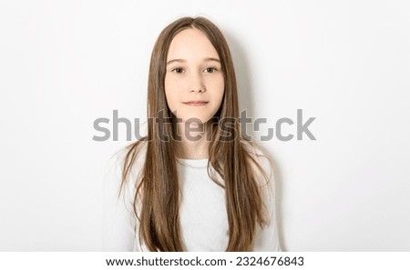 A Young brunette pre teen girl on studio white