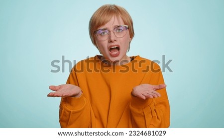 What Why. Sincere irritated woman in glasses raising hands in indignant expression, ask reason of failure demonstrating disbelief irritation by trouble. Pretty confused blonde girl on blue background Royalty-Free Stock Photo #2324681029