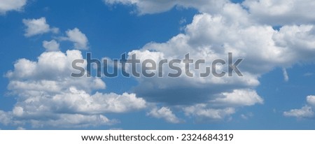 Blue sky background with white fluffy clouds.