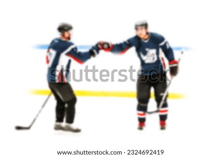 On hockey ice on white background - active game of hockey players in defocus - blurred backdrop for sports