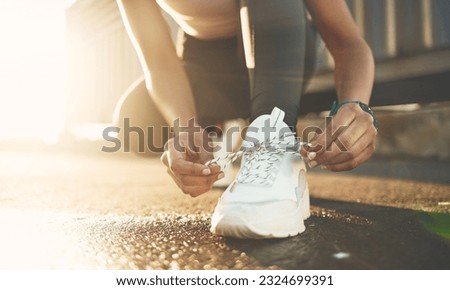 Tie, street or hands of person with shoelace for fitness training, exercise or running workout on road. Lace, zoom or leg of sports athlete with footwear ready to start exercising on ground in city Royalty-Free Stock Photo #2324699391
