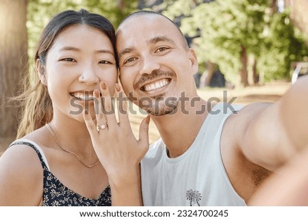 Selfie, engagement and portrait of couple in nature by outdoor park, garden or woods. Happy, smile and interracial engaged man and woman taking picture after romantic proposal with love and happiness
