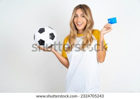Photo of happy cheerful smiling positive Young beautiful woman holding football ball over white background  recommend credit card