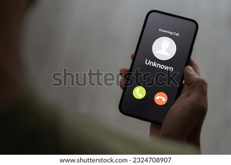 Scam call concept, person holding ringing phone with unknown caller, fraud attempt Royalty-Free Stock Photo #2324708907