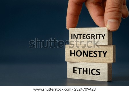integrity honesty ethics, Ethics and honesty in life and business, hand arranging wooden blocks with the text " Integrity Honesty copy space, beautiful navy blue background Royalty-Free Stock Photo #2324709423