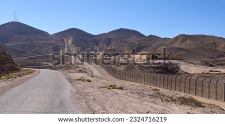 Restricted military zone along the border between Israel and Egypt along patrol road 10 in a remote part of the Negev desert and the Sinai desert. The border barbed wire fence along the road 10.