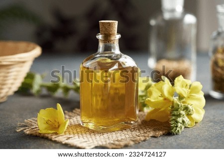 A bottle of mullein or Verbascum tincture with fresh plant on a table Royalty-Free Stock Photo #2324724127