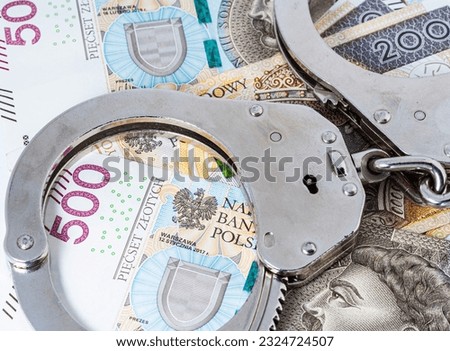 Police handcuffs and Polish banknotes. Crime and punishment concept. Economic crime.