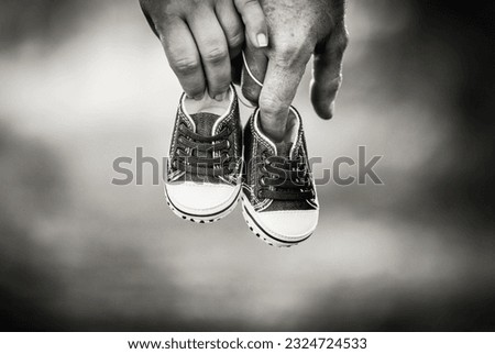 Pregnant couple holding baby shoes with their hands Royalty-Free Stock Photo #2324724533