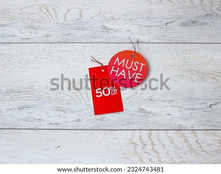 50% discount on red tag on a wood background. Time for discounts and promotions in sale.