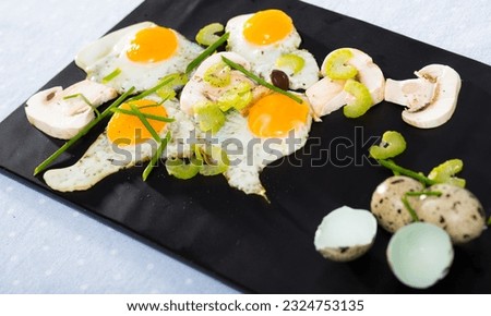 Plate with scrambled quail eggs with champignons mushrooms on table