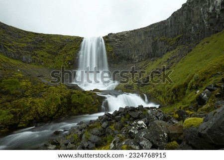 long exposure photo ; beautiful waterfall Bæjarfoss in summer, Ólafsvík, Iceland