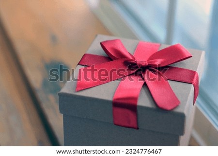 Gift box on wooden window background as a gift for Christmas, New Year, Valentine's Day or anniversary.