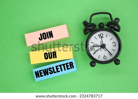 bell clock and colored paper with the words Join Our Newsletter. business marketing concept