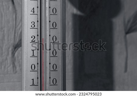 Gray thermometer hanging near the wall. The thermometer shows more than 20 degrees Celsius Royalty-Free Stock Photo #2324795023