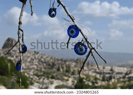 The evil eye tree typically features a blue glass bead or a charm in the shape of an eye hanging from a tree or attached to a decorative object.