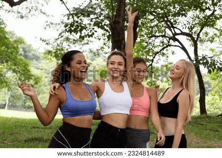 Happy smiling female friends. Woman talking and having fun in park after finish fitness yoga class exercise on weekend morning.
