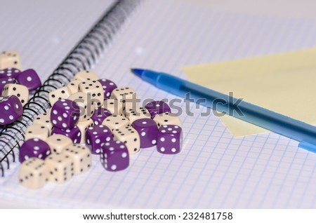 open exercise book with sticky card, pen and dices - stock photo