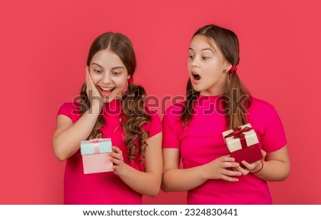 surprised children with present boxes on red background