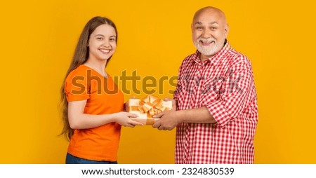 happy child and granddad with present box for anniversary