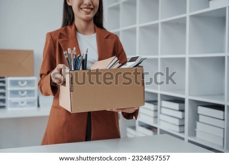 Close up Asian business office woman resignation, carrying her personal stuff, happy to leave her job or change job positions. Royalty-Free Stock Photo #2324857557