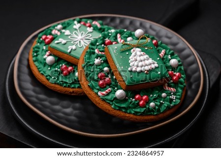 Beautiful Christmas or New Year colorful homemade gingerbread cookies on a ceramic plate on a dark concrete background