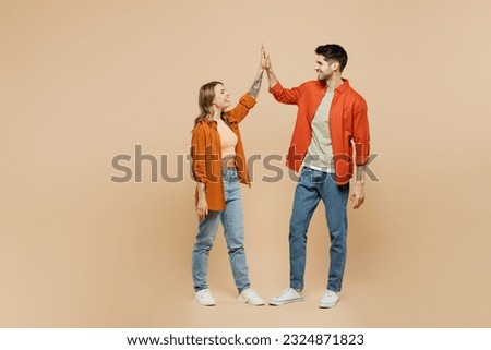 Full body young couple two friends family man woman wear casual clothes together meeting together greeting giving high five clapping hands folded isolated on pastel plain light beige color background