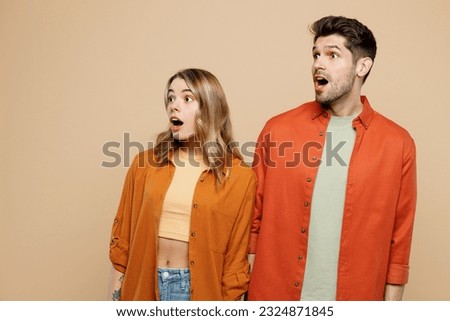 Young shocked surprised amazed impressed couple two friends family man woman wear casual clothes looking aside on area together isolated on pastel plain light beige color background studio portrait Royalty-Free Stock Photo #2324871845