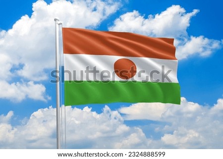 Niger national flag waving in the wind on clouds sky. High quality fabric. International relations concept