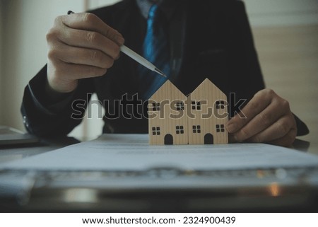 Female woman hands holding home model, small miniature white toy house. Mortgage property insurance dream moving home and real estate concept