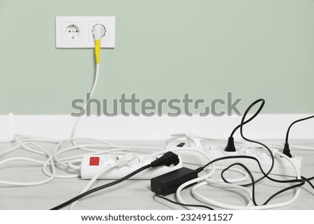 Power strips with different electrical plugs on floor indoors, space for text Royalty-Free Stock Photo #2324911527